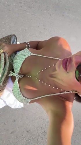 Woman in crocheted bikini walks Kuta Selatan pathway early morning