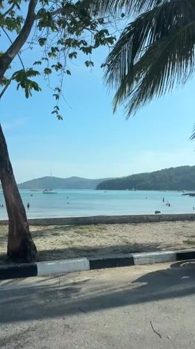 Vehicles parked along beach road in Tambon Wichit, Thailand