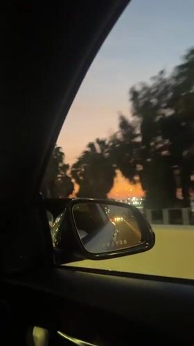 Driver films side mirror showing white car behind in Arica