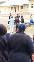 Young people gather at yellow building in Akwanga schoolyard