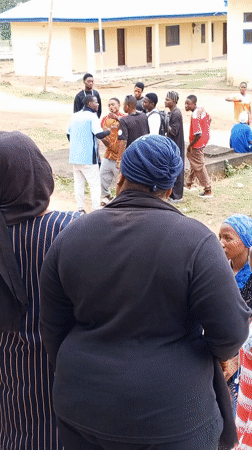 Young people gather at yellow building in Akwanga schoolyard