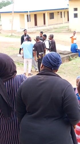 Young people gather at yellow building in Akwanga schoolyard