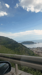 Vehicle passenger films panoramic view of coastal Budva