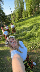 Women in floral outfits gather for selfies in Markovo