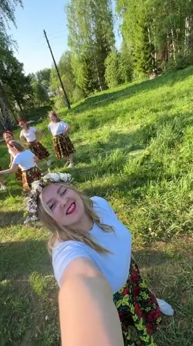 Women in floral outfits gather for selfies in Markovo