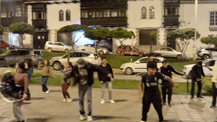 Young people dance in Cuzco plaza at night