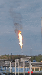 Flare stack burning at an industrial facility