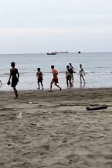 Young men play beach soccer in Lhokseumawe, Indonesia