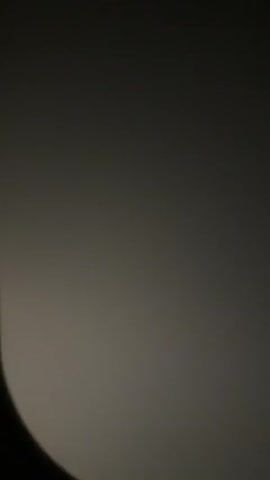 A dark video captures a dimly lit, possibly circular, area. The lighting is inconsistent, with a brighter, glowing section on the right and a darker section on the left. The image appears to be moving slightly, suggesting it might be filmed from a moving object or handheld. There is no discernible activity or objects within the frame other than the light and shadow play.