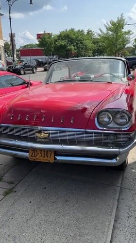 Classic red Chrysler convertible parked on a New York sidewalk