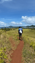 Man walks dirt path through fields in Dapa, Philippines