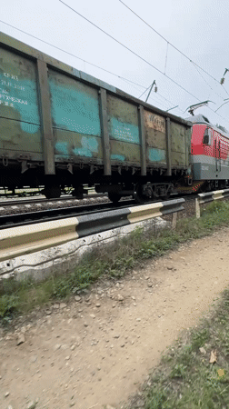 Freight train with colored hopper cars observed in Bira, Russia
