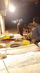 Nighttime street food stall bustles with cooking activity
