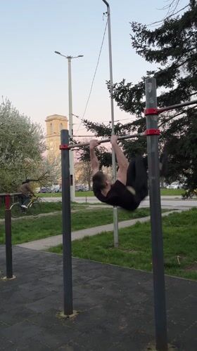 Man performs muscle-up exercise at Ruse park fitness equipment