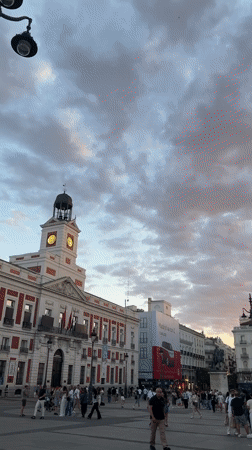 Evening crowds gather in Madrid plaza with street performer
