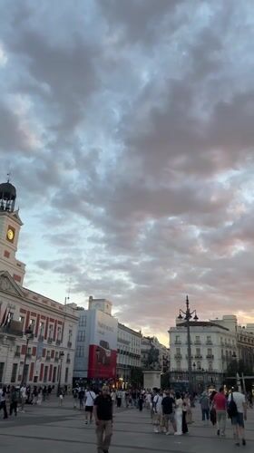 Evening crowds gather in Madrid plaza with street performer