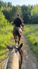 Three friends enjoy afternoon horseback ride through Russian countryside
