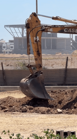Construction excavator operates at El Jadida site under clear skies