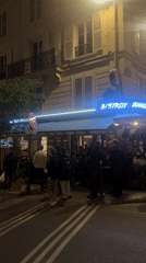 Evening crowd gathers outside Bistrot Smile in Paris