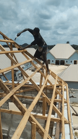 Construction worker builds roof frame in Agbarha-Otor, Nigeria