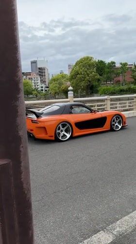Modified orange Mazda RX-7 spotted parked on Osaka bridge