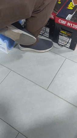 Men Play Cards on Car Battery Stacks in Warehouse