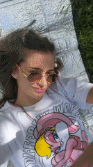 Woman enjoys leisurely outdoor selfie session on sunny afternoon