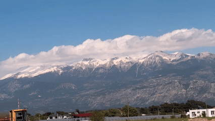 Snow-covered mountains viewed from Seydikemer under blue skies