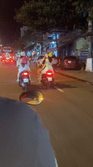 Scooter rider travels through Nha Trang streets at night