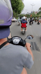Scooter rider with mounted phone navigates busy Hanoi streets