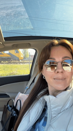 Woman enjoys music in car with sunroof in Riga