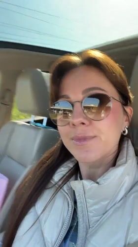 Woman enjoys music in car with sunroof in Riga