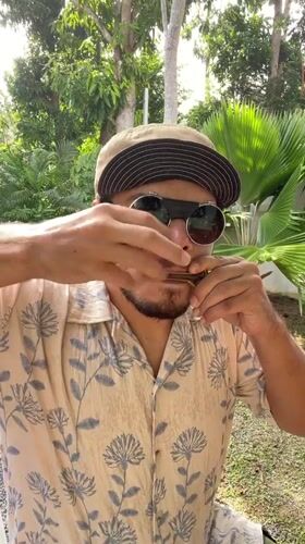 Street musician performs harmonica and jaw harp in Rawai