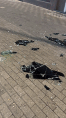 Broken glass scattered across a Caracas street at night