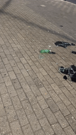 Broken glass scattered across a Caracas street at night