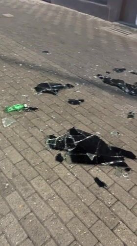 Broken glass scattered across a Caracas street at night
