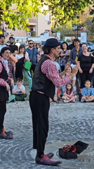 Street performers juggle for crowd on cobblestone square