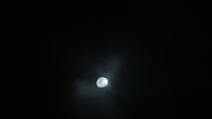 Gibbous moon observed through cloudy night sky in Porlamar