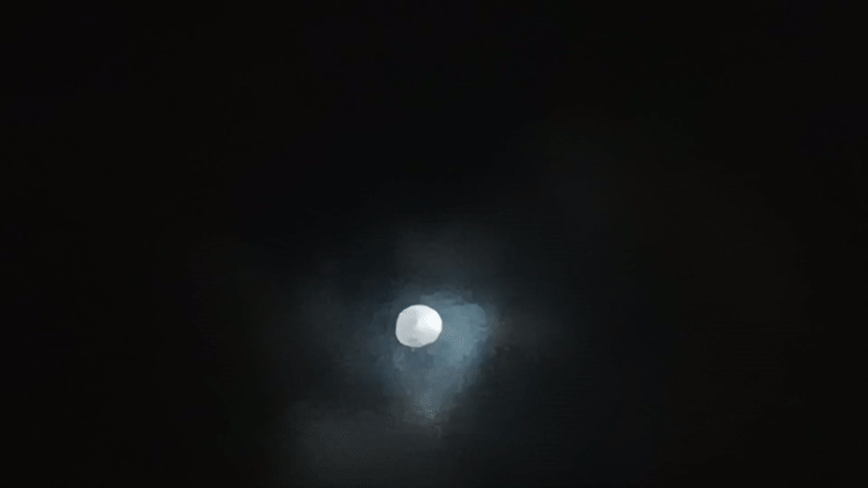 Gibbous moon observed through cloudy night sky in Porlamar