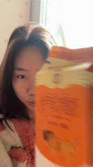Woman in pink robe drinks juice, takes selfie in Chongqing