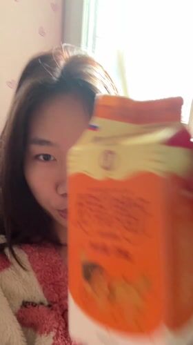 Woman in pink robe drinks juice, takes selfie in Chongqing