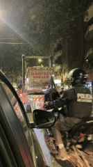 Police motorcycle passes stopped dump truck in Buenos Aires
