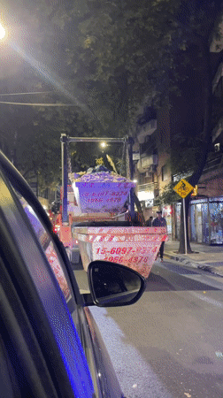 Police motorcycle passes stopped dump truck in Buenos Aires
