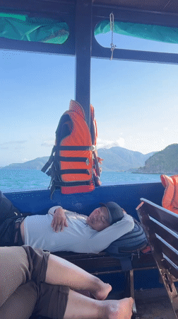 Man sleeps on boat bench in Vietnam