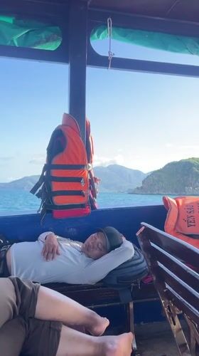Man sleeps on boat bench in Vietnam