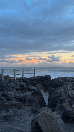 Sunset coastal activity documented along Mengwi Indonesia rocky shoreline