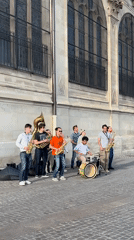 Eight-piece street band performs in Paris on sunny afternoon