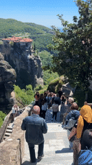 Tourists photograph ancient monasteries at Greece's Meteora rock formations