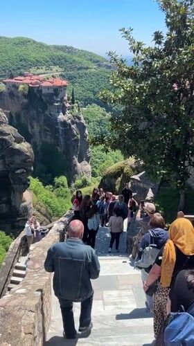 Tourists photograph ancient monasteries at Greece's Meteora rock formations