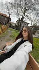 Woman sits contemplatively on park bench in Sofia